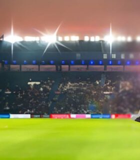 World Cup 2026 executive protection Mexico City concept with security professional holding trophy inside a packed stadium under bright lights